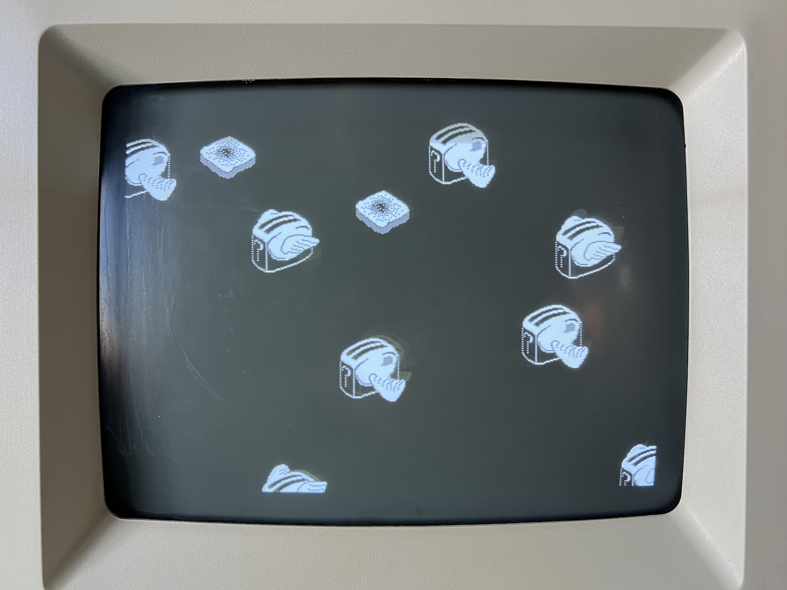 The screen of a Macintosh SE/30 showing flying toasters.